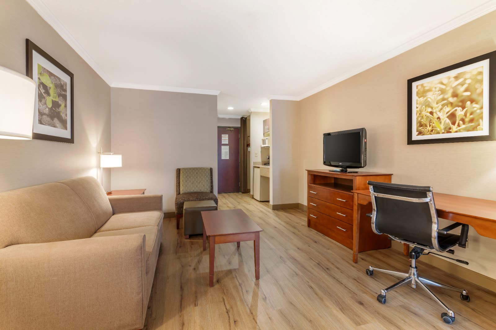 King Suite separate sitting area with sofa and work desk at Syracuse Grand hotel