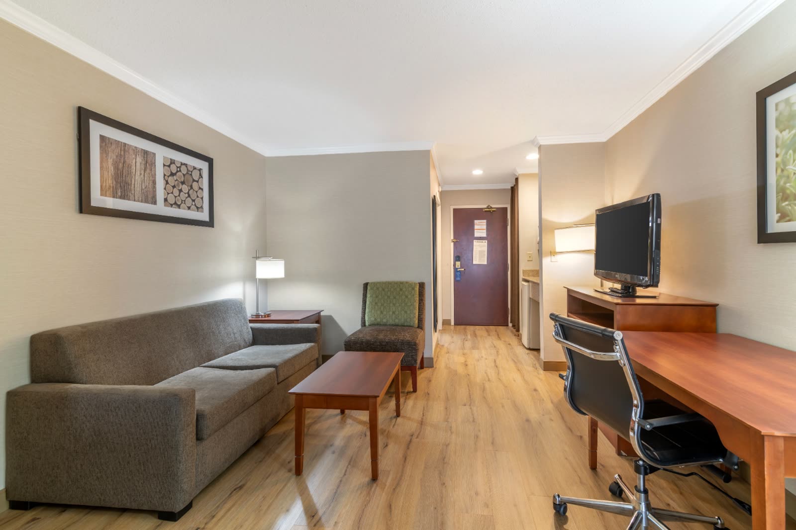 Two Queen Suite separate sitting area with sofa and work desk at Syracuse Grand hotel